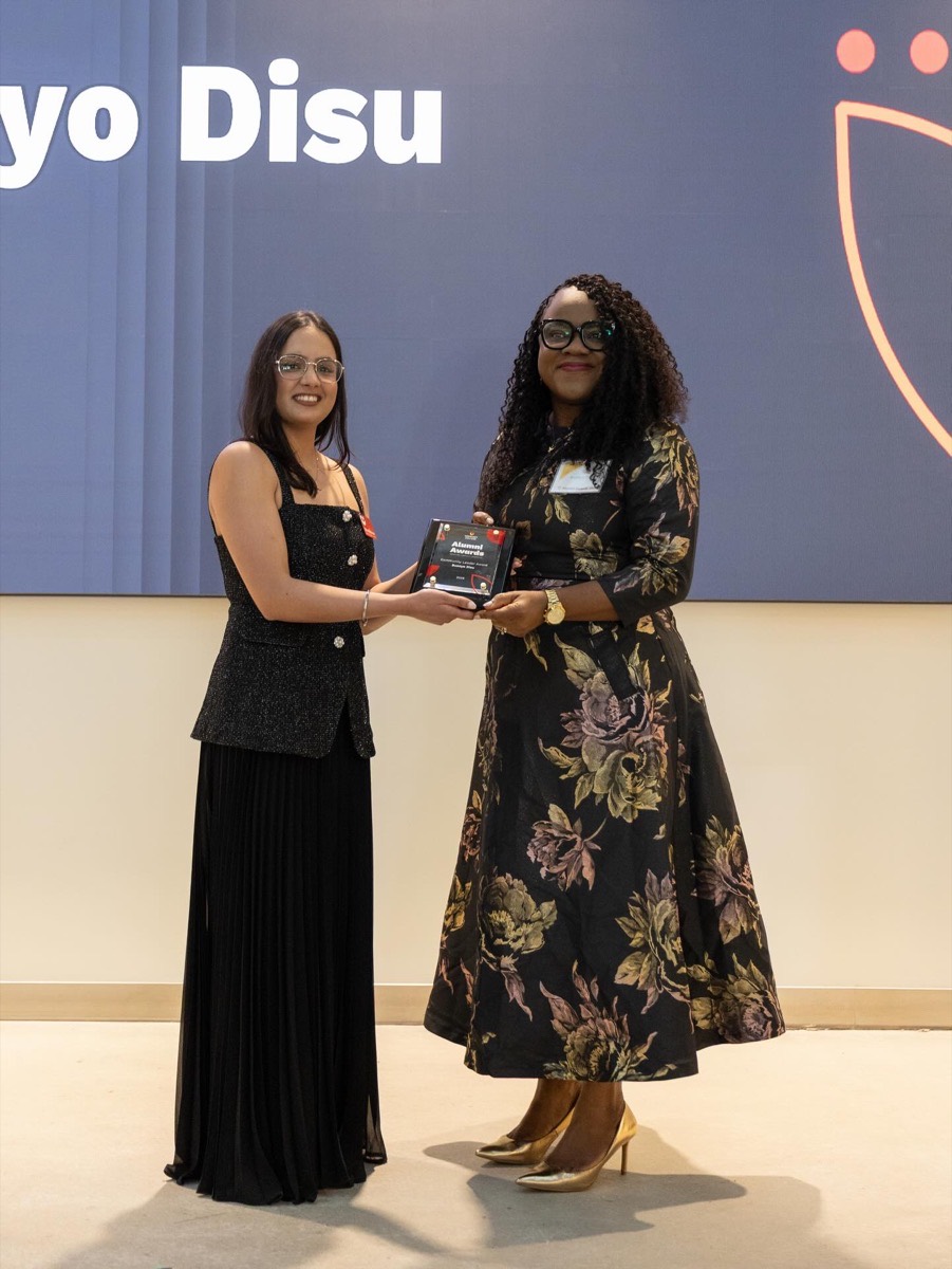 Busayo Disu receiving the Community Leader of the Year Alumni Award on stage