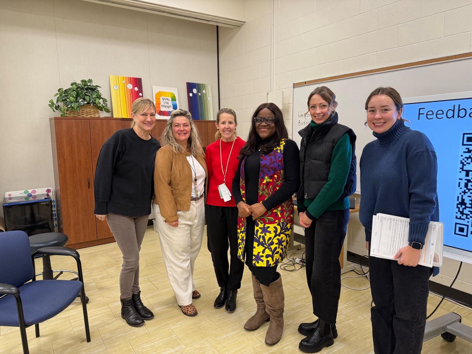 Busayo Disu with a small group of school staff in a meeting room after a session