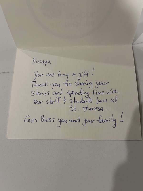 Handwritten card from St. Theresa: Busayo, you are truly a gift! Thank you for sharing your stories and spending time with our staff and students here at St. Theresa. God bless you and your family!