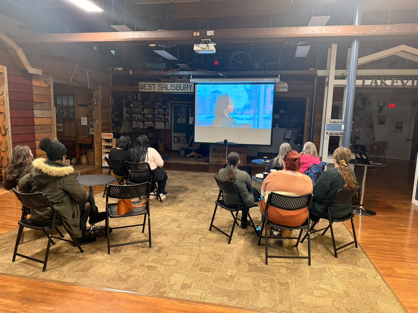 A community room watching one of Busayo Disu&rsquo;s documentary screenings, seated in a semicircle facing the projected film